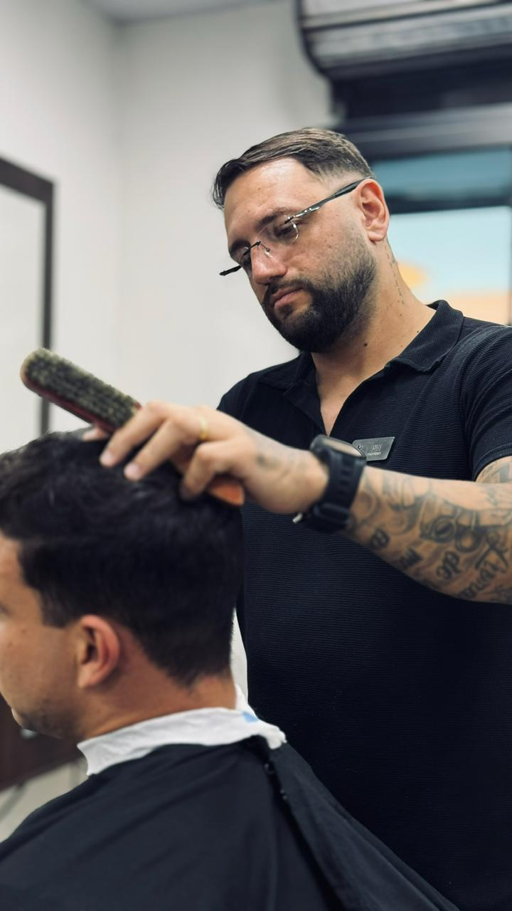 Barbeiro do Método PH finalizando um corte com escova